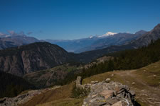 Dal Colle Ranzola verso ovest. In primo piano il muretto anti-Napoleone; nel piano intermedio lo spartiacque tra la Val d'Ayas e la vallata principale, con la Testa di Comagna (a sinistra), il Col de Joux (la depressione al centro) e le prime pendici dello Zerbion (a destra). Sullo sfondo, a sinistra il gruppo del Mont Emilius che domina la città di Aosta (visibile nella foschia al centro dell'immagine); a destra il Monte Bianco e la Puinta Walker (Grandes Jorasses) che occhieggia dietro il crinale.