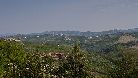 Dalla strada di langa che unisce San Giuseppe di Monforte alla antica Cascina Bricco lo sguardo spazia su campagne, castelli e villaggi. Sullo sfondo, il castello di Serralunga.