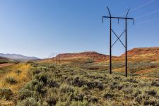 A sinistra, la strada sterrata che aggira le Copper Mountains, affiancata dai tipici tralicci (di solito in legno, qui in metallo) e dalle immancabili colline di arenaria rossa.